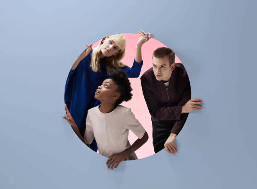 Three people looking outside a huge circle inside a wall