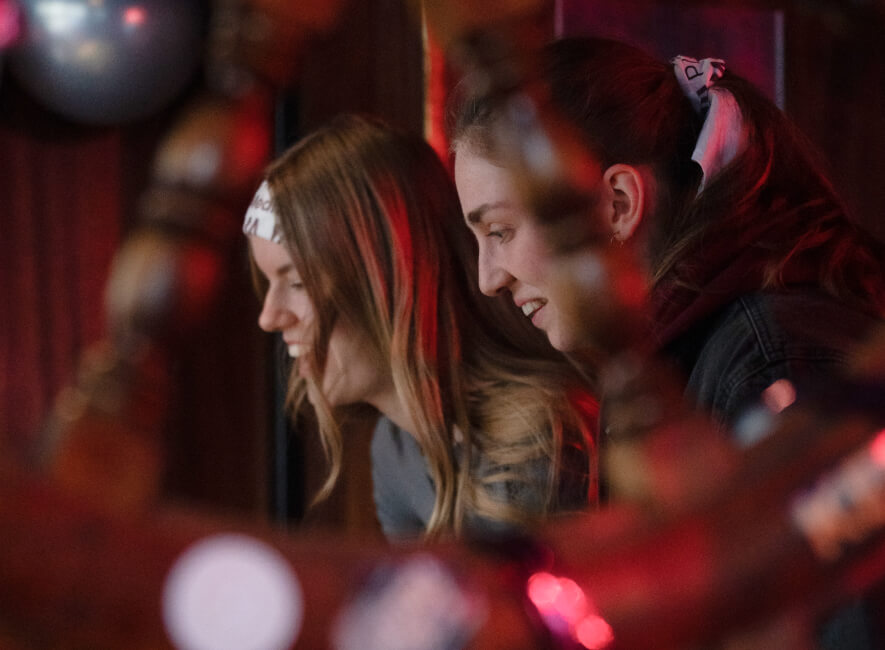 two women play table football and smile